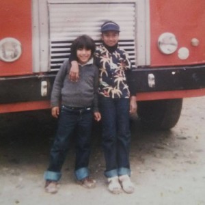 Brother and sister posing in front of a bus