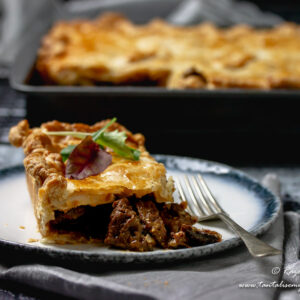 Slice of Cape Malay Pepper Steak Pie with pie tray in back